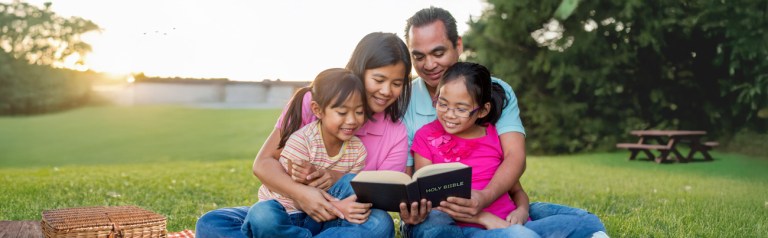 a family enjoying a picnic by a lake have family devotions which help them grow spiritually through discipleship