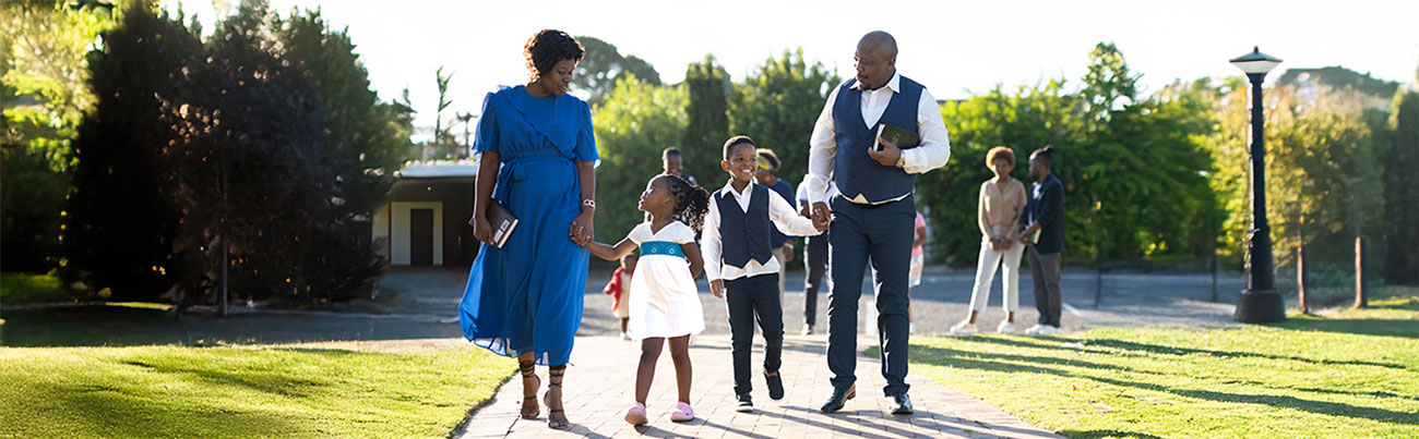 A young family walking to Sunday morning worship carrying their Bibles