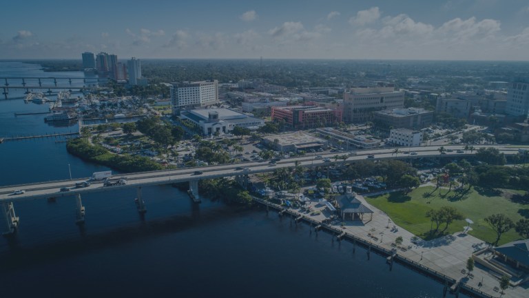 An aerial view of the south end of the Caloosahatchee Bridge and the waters of the Caloosahatchee River, showing off the downtown river district in Fort Meyers, Florida, a location of FamilyLife's Weekend to Remember® marriage retreat event.