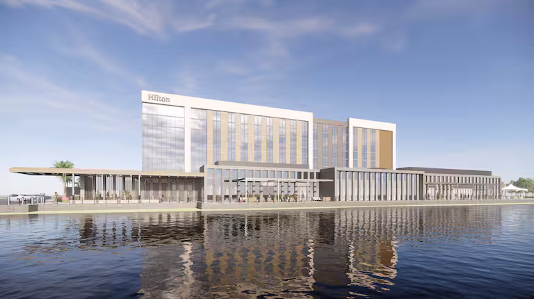 A view of the Hilton Jacksonville at Mayo Clinic hotel, an architecturally designed building seated on the edge of a large reflective pond in Jacksonville, Florida, a location of FamilyLife's Weekend to Remember® marriage retreat event