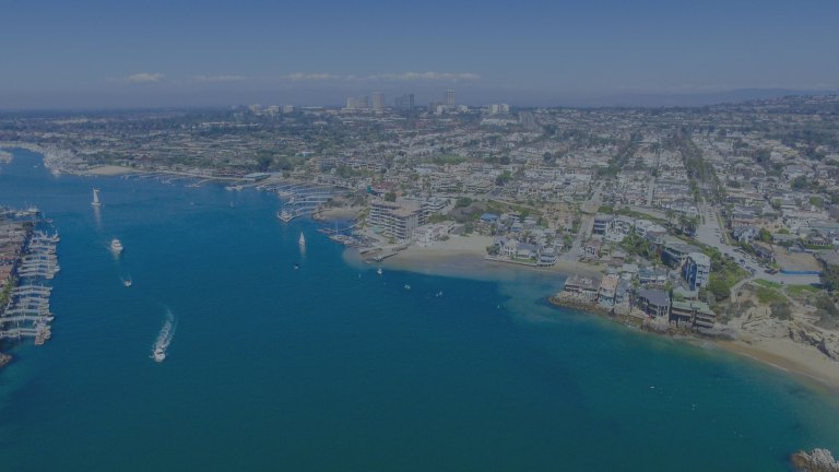 A view over the East Passage of Narragansett Bay showing off the beautiful blue waters along the coastline, with an eye toward the horizon where downtown city buildings stand in Newport, Rhode Island, a location of FamilyLife's Weekend to Remember® marriage retreat event.