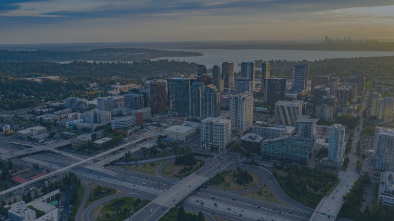 A network of highways in front of a sea of city buildings, and Lake Washington, which separates Bellevue's high-rise cityscape from Seattle, Washington, a location of FamilyLife's Weekend to Remember® marriage retreat event.