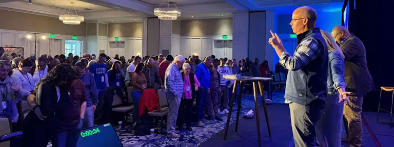 A view from the stage looking at the audience and Weekend to Remember speakers who are praying for the married couples attending the popular event