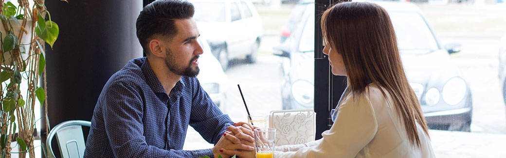 man and woman sitting at a table having a conversation